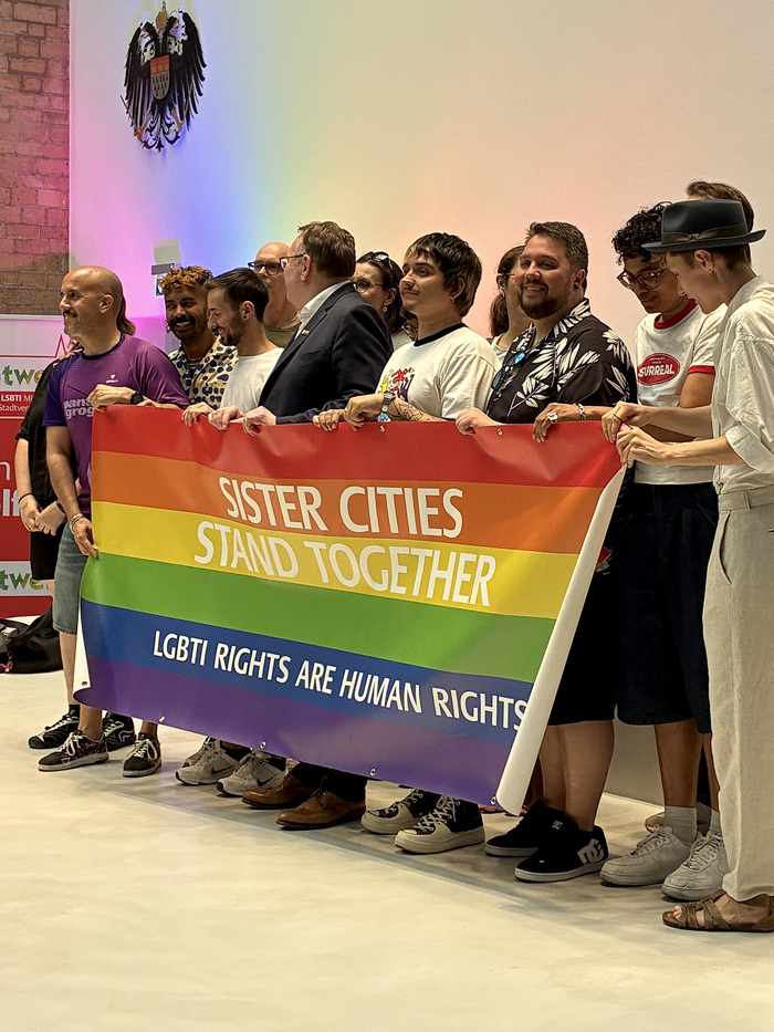 AktivistInnen und Unterstützer*innen der queeren Community mit Plakat Sister Cities
